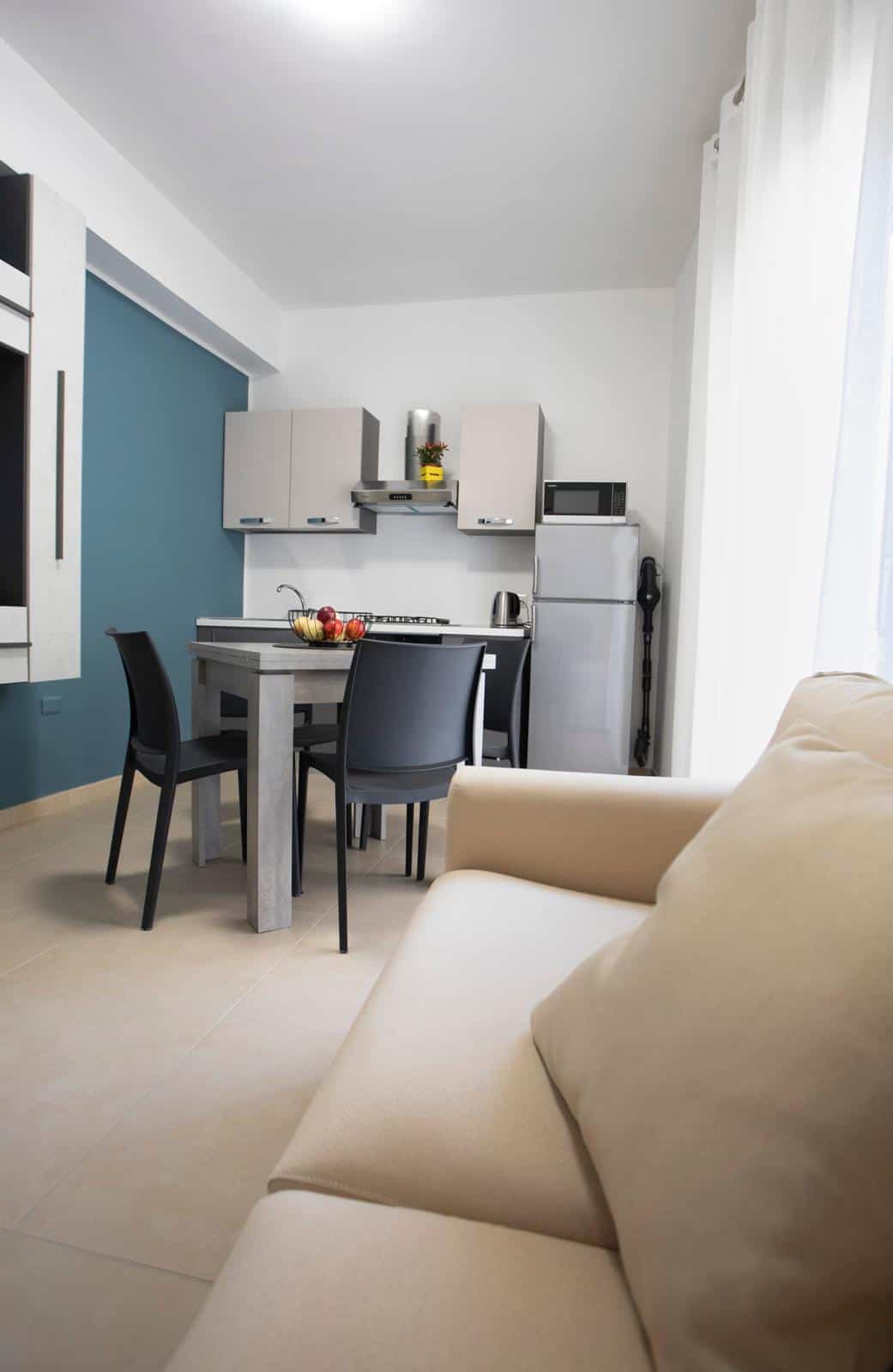 Appartamento moderno con cucina compatta e zona soggiorno luminosa, ideale per soggiorni confortevoli e funzionali. Design minimalista con mobili pratici e colori neutri, perfetto per vivere in città.
