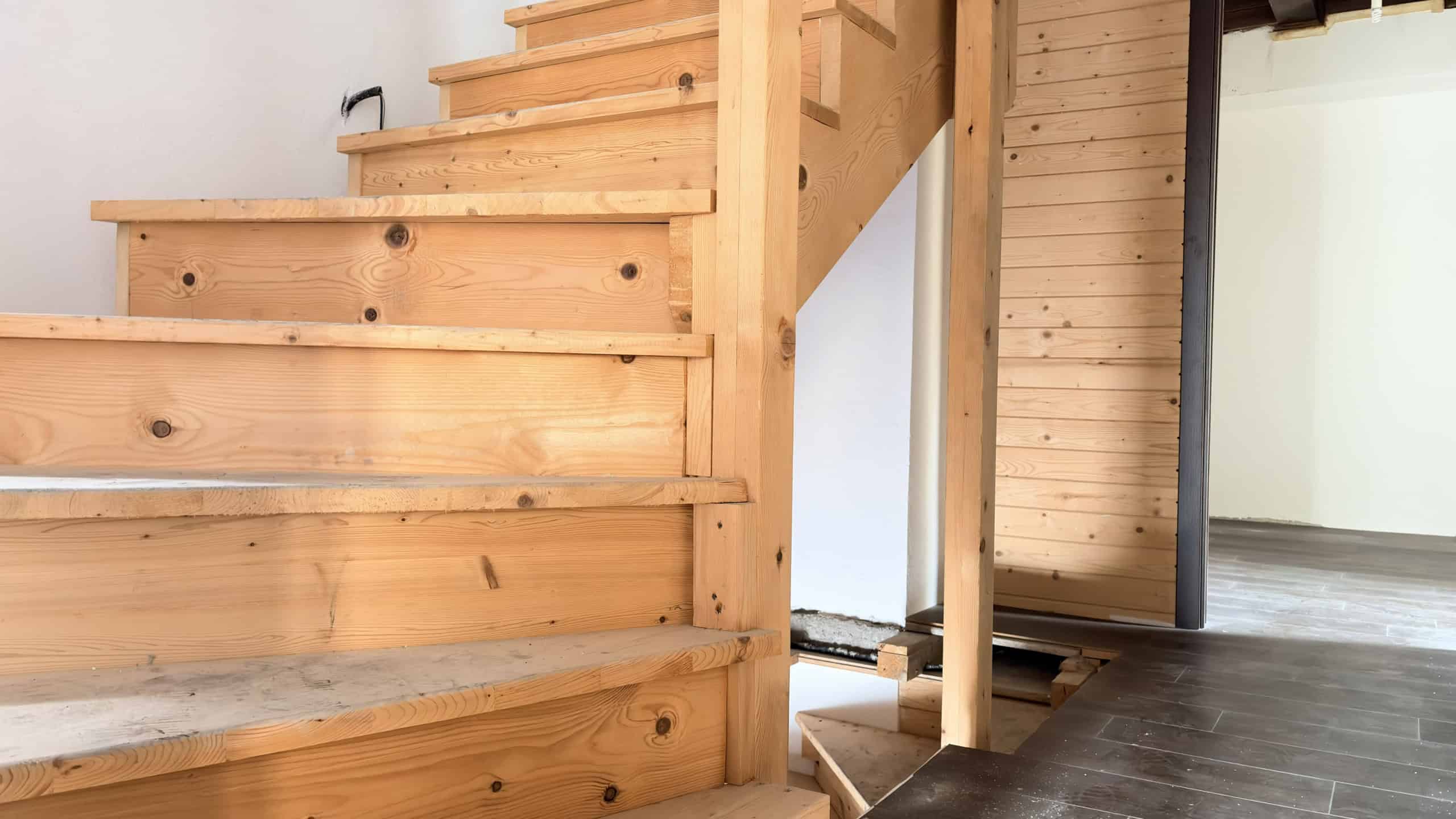 Pavimento in legno e scala in legno naturale in un interno moderno e luminoso.