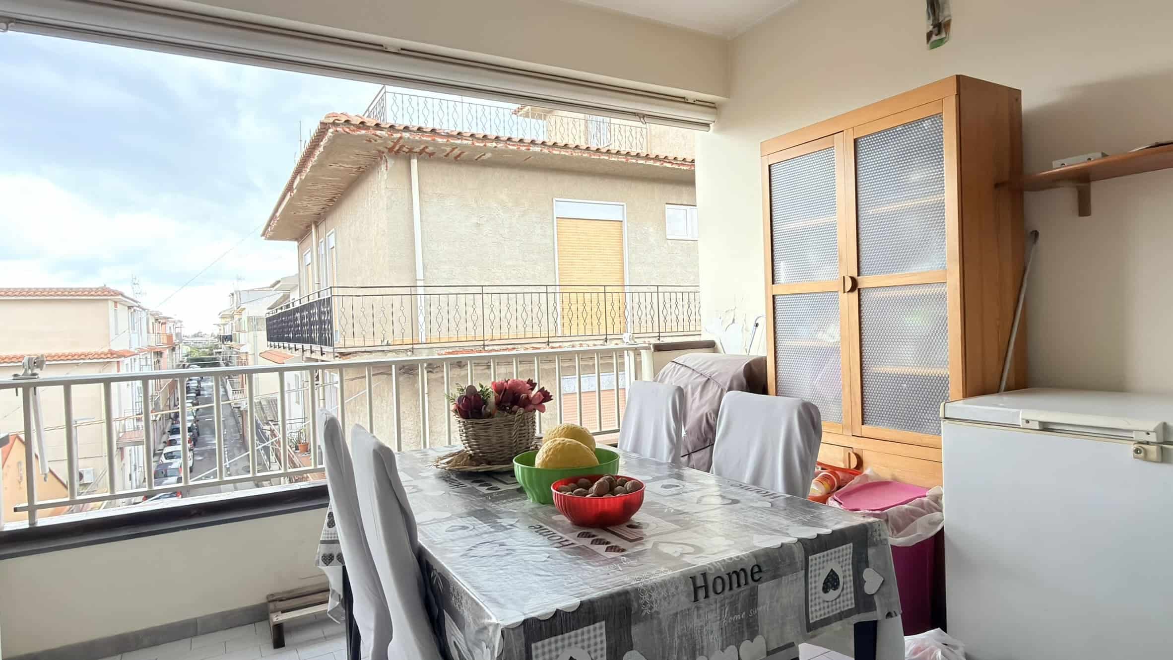 Mensa da pranzo con vista su balcone e quartiere residenziale, arredamento moderno e luminoso, ideale per vivere momenti di convivialità in casa.