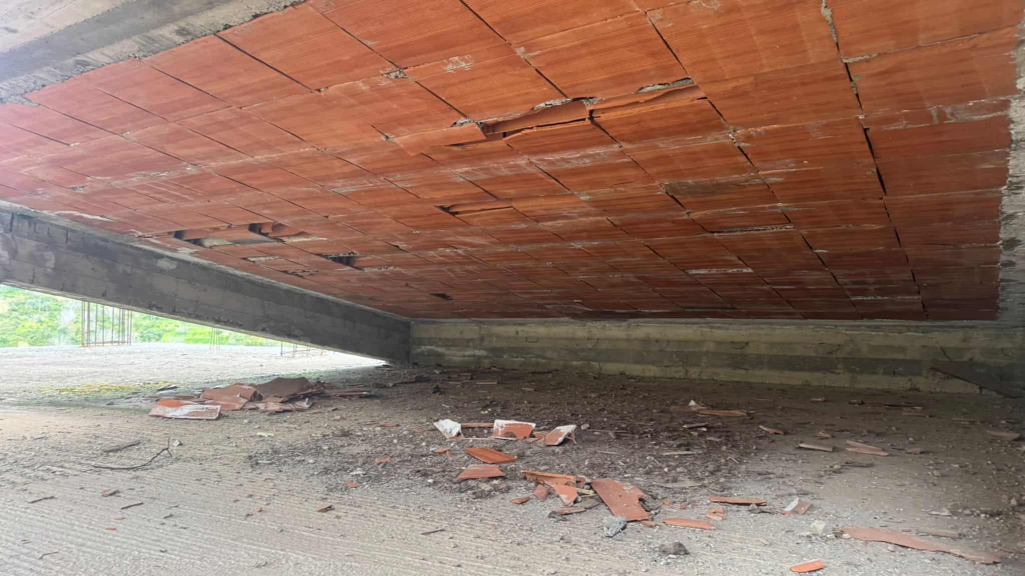 Finestra sotto il ponte con mattoni rossi e pavimento in cemento, visibile da una prospettiva bassa.