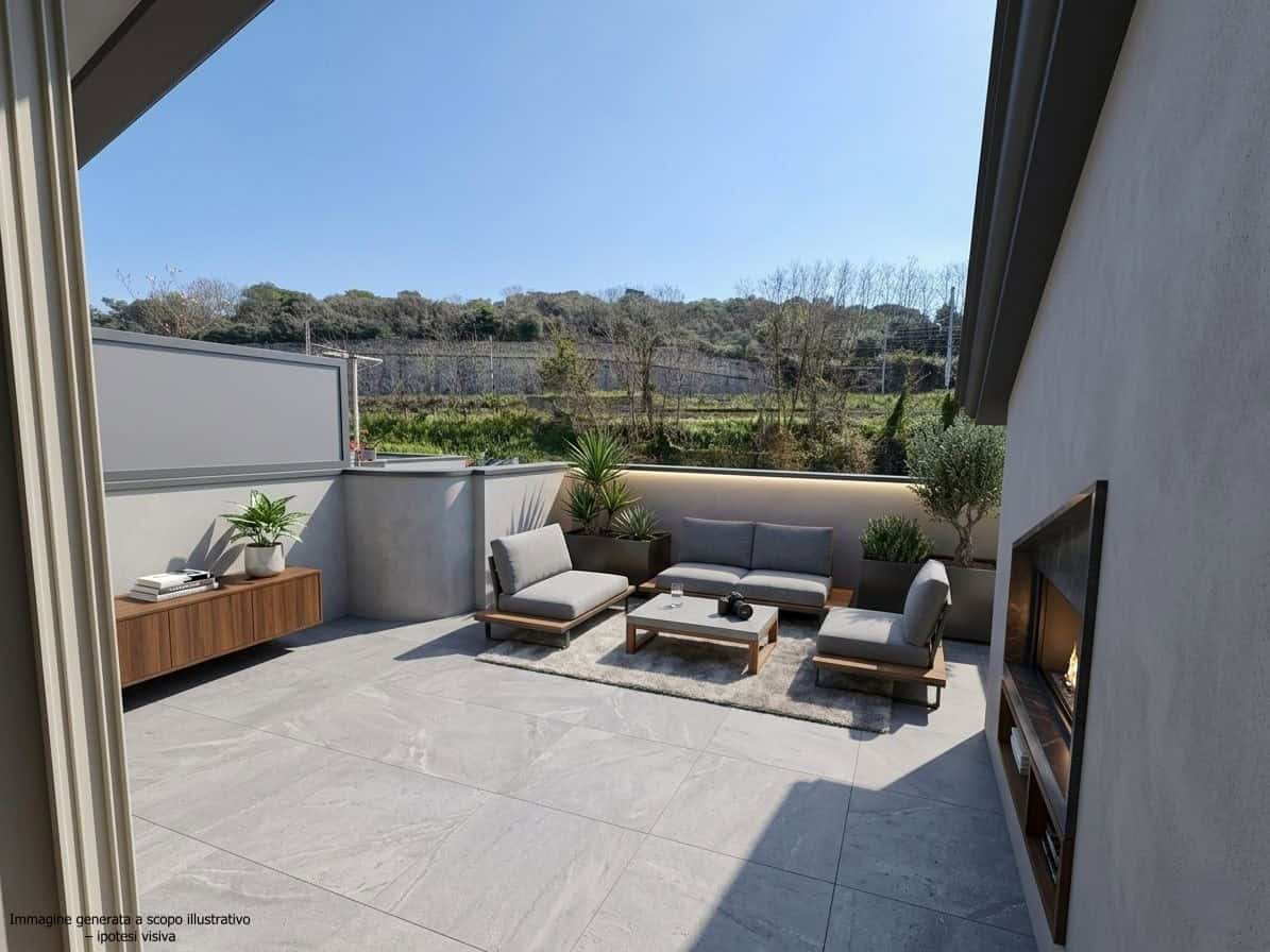 Elegante terrazza esterna con divani e tavolino, vista panoramica su colline e cielo sereno, perfetta per relax e convivialità all'aperto.