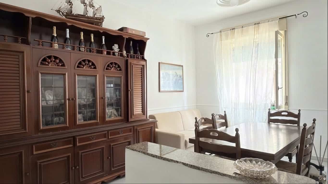 Mobili in legno antico in soggiorno con tavolo da pranzo e sedie, luce naturale, ambiente accogliente e tradizionale, ideale per case di charme e ristrutturazioni di interni classici.