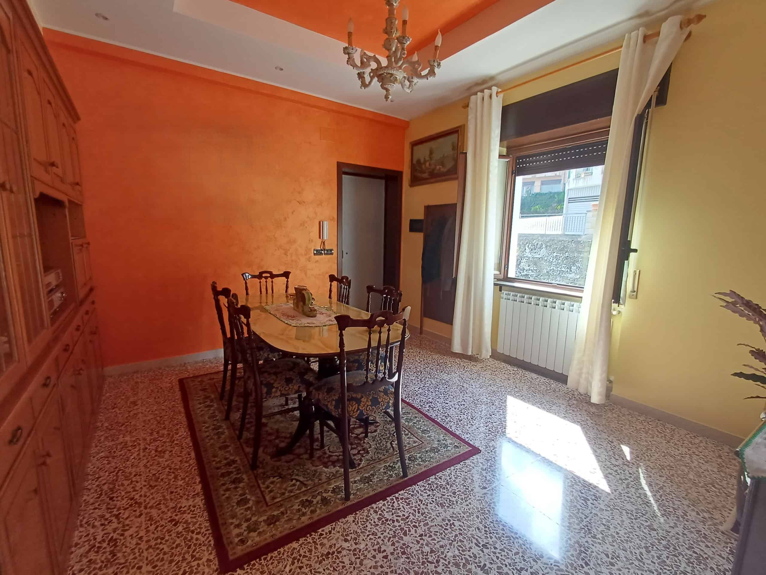 Appartamento luminoso con sala da pranzo, pareti colorate e grandi finestre che lasciano entrare molta luce naturale, ideale per vivere in comfort e stile.