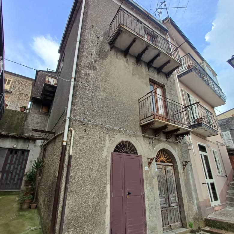 Balcone e facciata di un edificio storico in zona urbana, con dettagli architettonici tradizionali e accesso tramite scale esterne, in un contesto residenziale italiano.