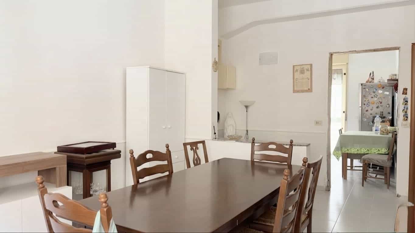 Tavolo da pranzo in legno con sedie in stile classico in un ambiente domestico luminoso e accogliente.
