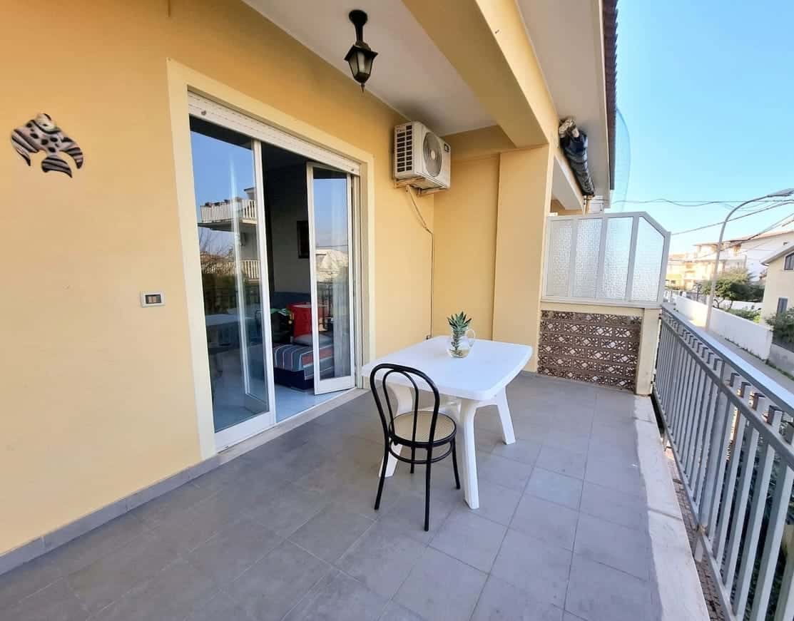 Ampio balcone con tavolo e sedia, vista su quartiere residenziale, ideale per relax e cene all'aperto, con aria condizionata e accesso diretto alla zona giorno.