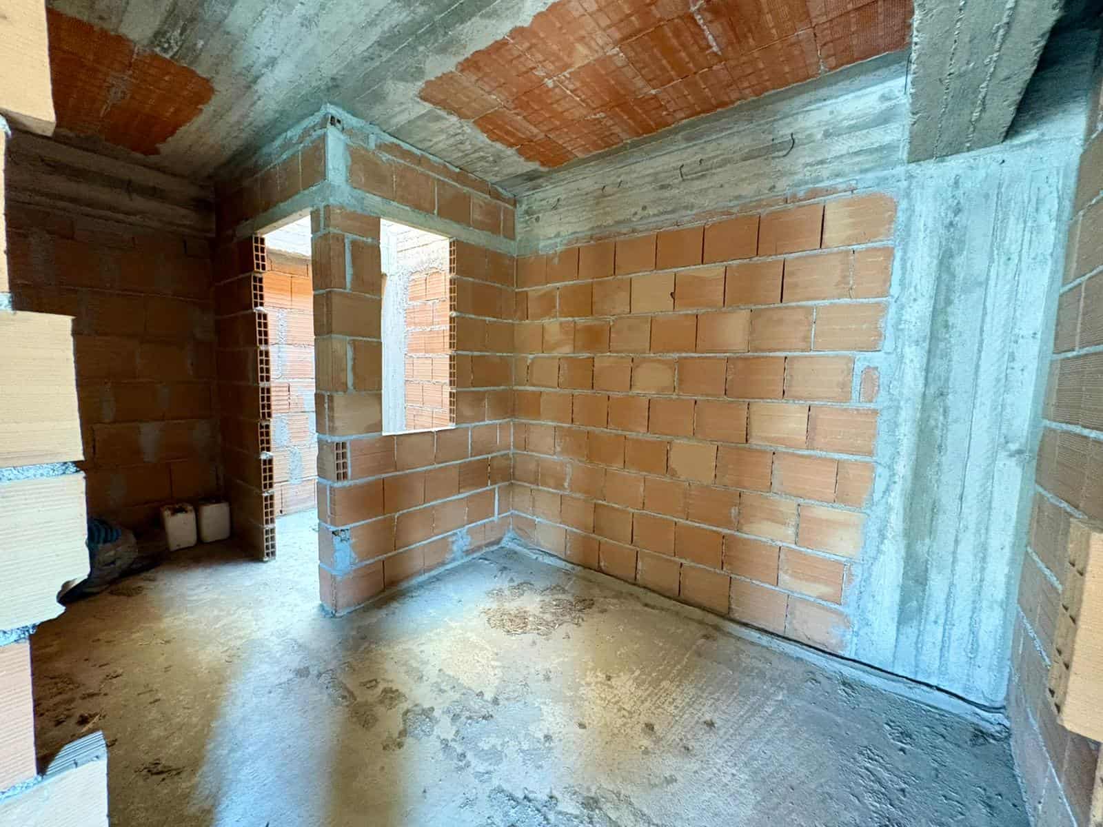 Cattura di un ambiente in costruzione con pareti in mattoni e struttura in cemento, pronto per essere completato. Ideale per progetti di ristrutturazione e nuove costruzioni residenziali o commerciali.