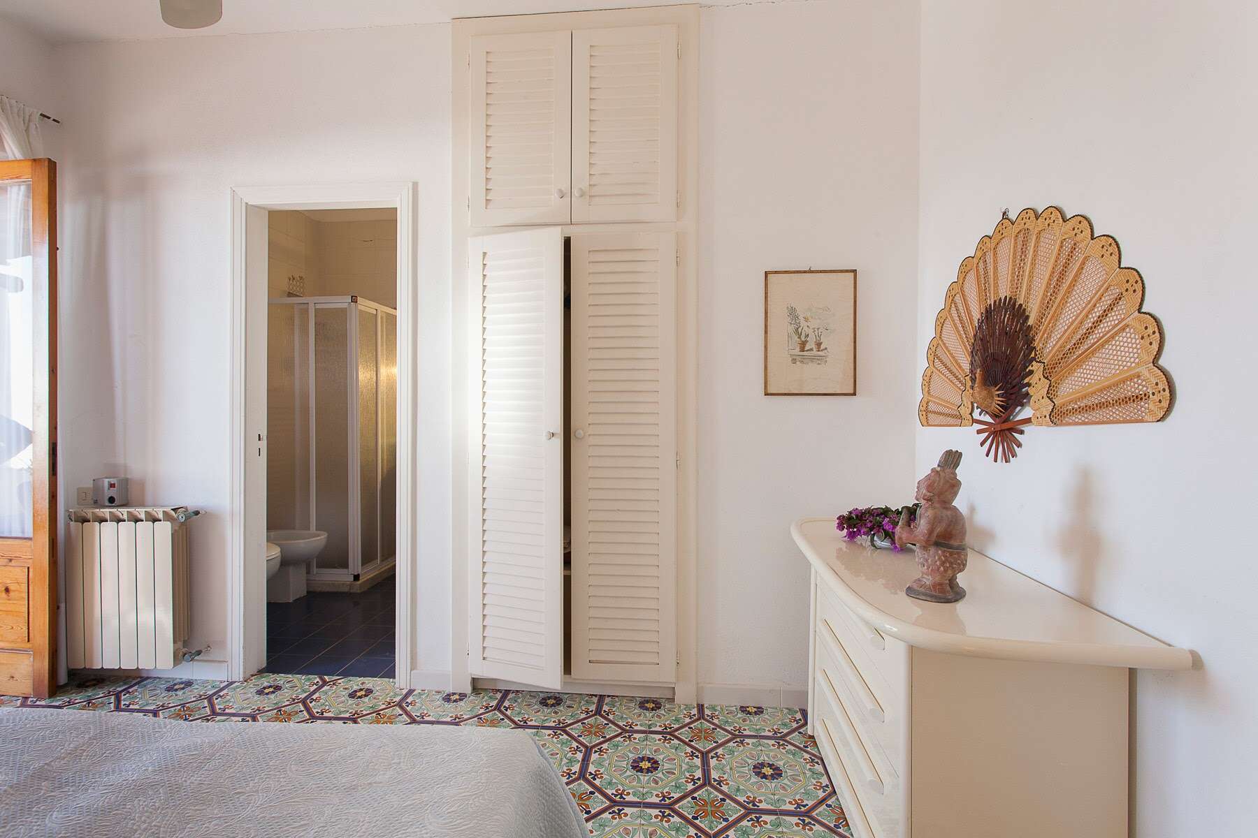 Interno di una camera da letto con armadio a muro, decorazioni e accessori, ambiente luminoso e accogliente, ideale per affitti turistici o residenziali in Italia.
