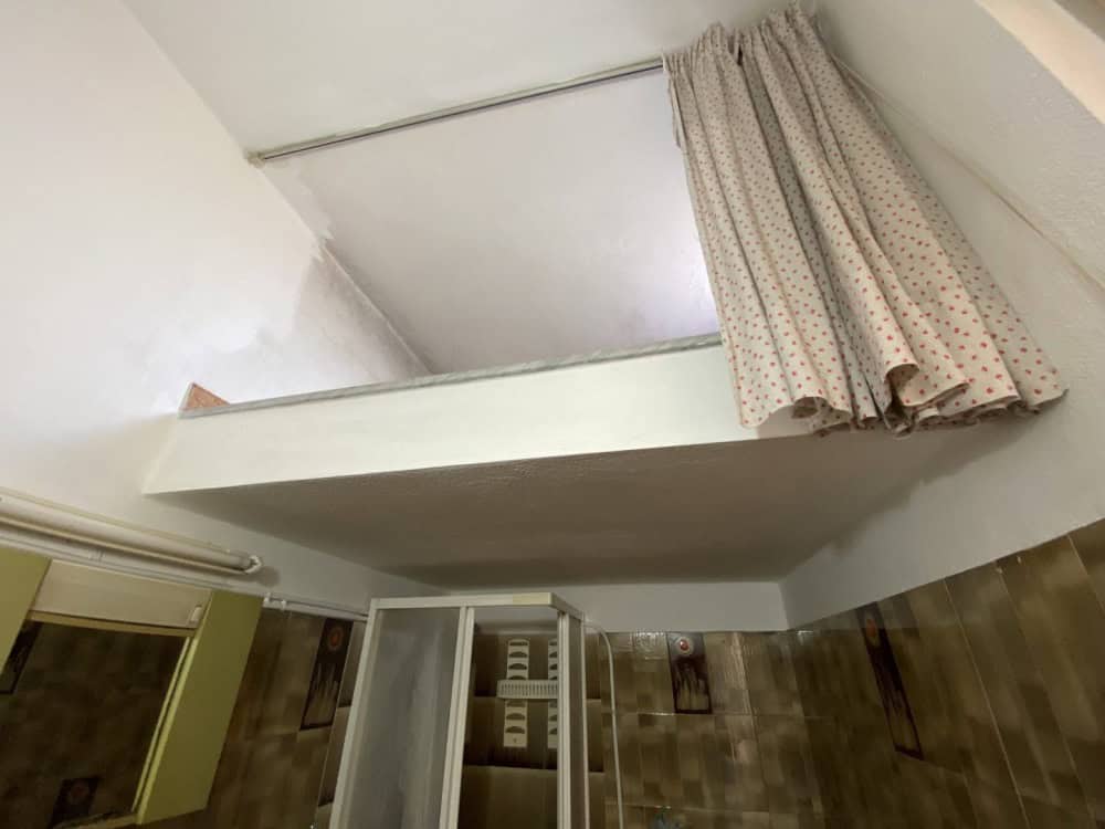 Tappeto di tessuto con motivo a pois appeso a una parete bianca in un ambiente domestico.