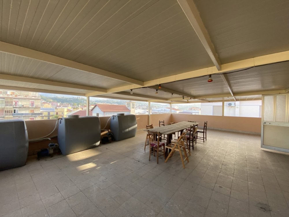 Ampia terrazza coperta con vista panoramica, ideale per eventi e momenti di relax all'aperto, dotata di spazio per tavoli e sedie, perfetta per vivere all'aperto in ambienti residenziali o commerciali.