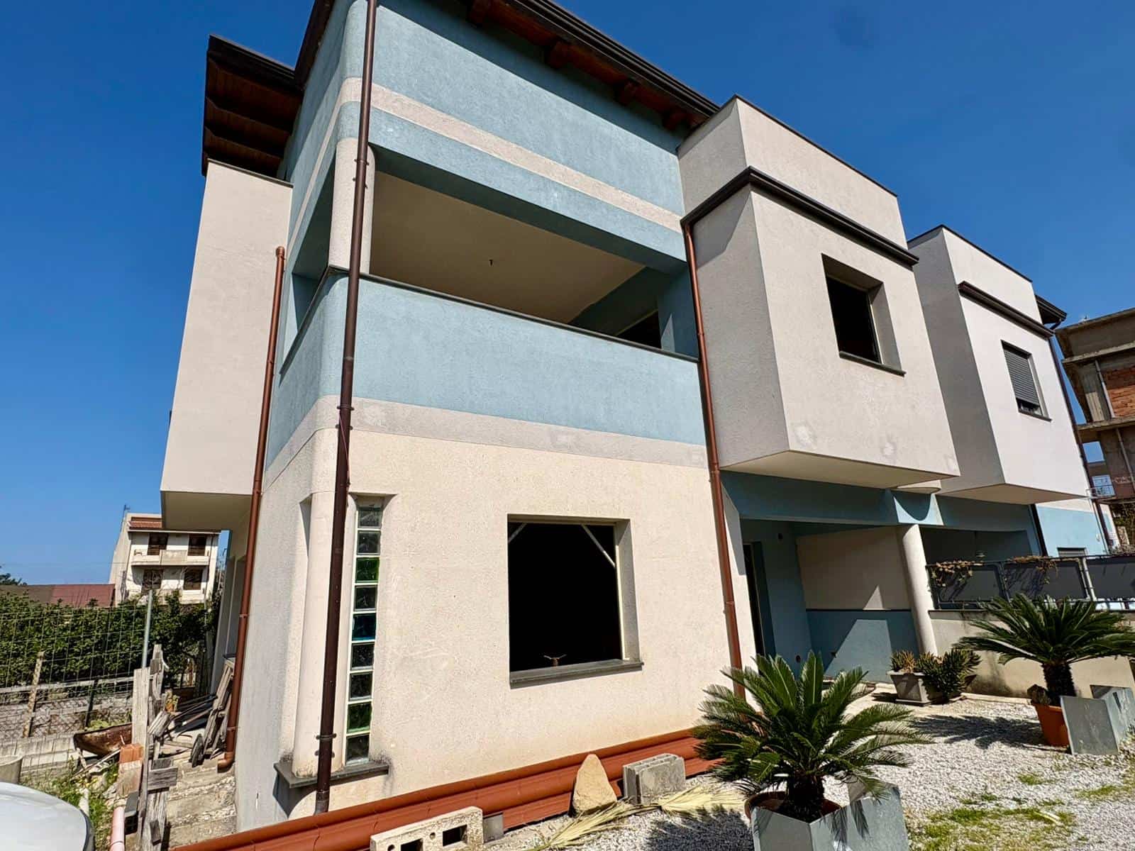 Edificio residenziale moderno con balconi e giardino ben curato, esempio di architettura contemporanea a NextCasa.