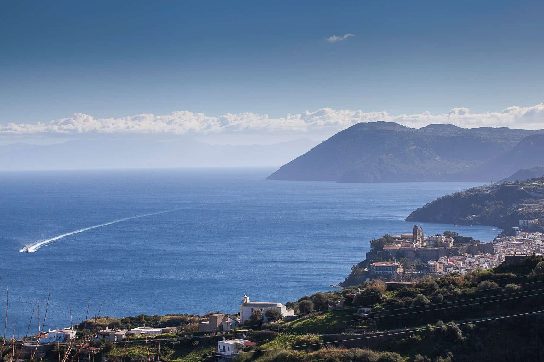 Spiaggia panoramica con vista sul mare e sulle montagne, ideale per vacanze rilassanti e attività all'aperto in Italia.