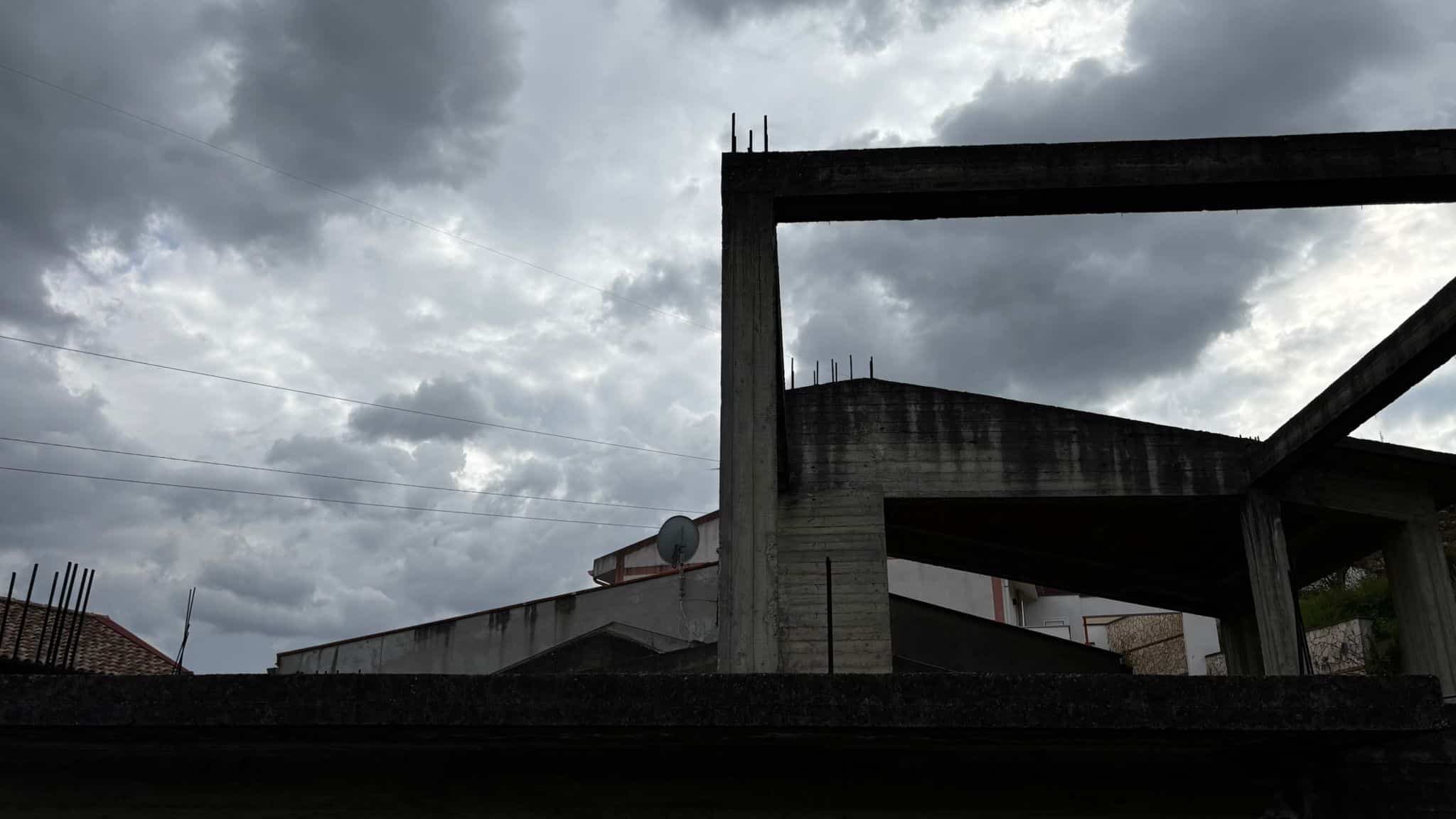 Pannello di costruzione in cemento sotto un cielo nuvoloso, immagine di un edificio in fase di realizzazione con struttura in cemento armato.