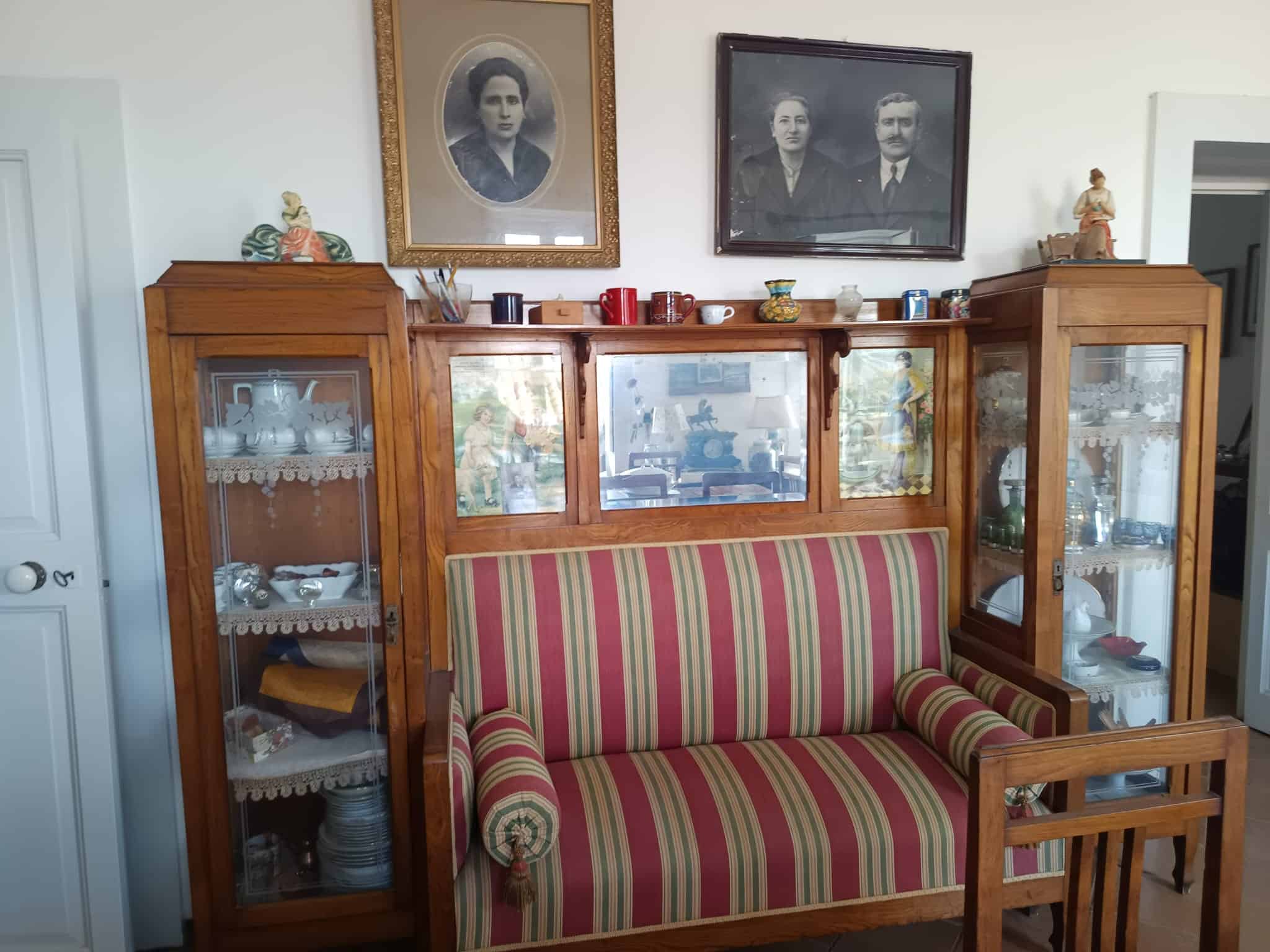 Mobili antichi in stile vintage con vetrine in legno e oggetti decorativi, ambientazione di una sala da pranzo o soggiorno classico.