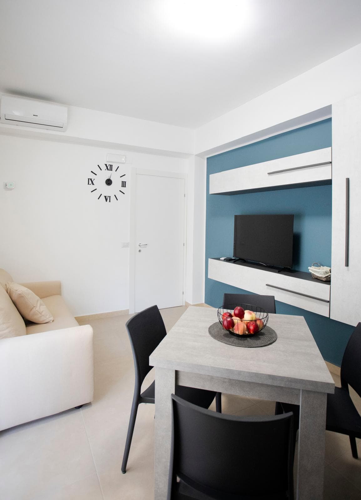 Aria condizionata moderna e soggiorno con TV in un appartamento elegante a NextCasa, Milano.