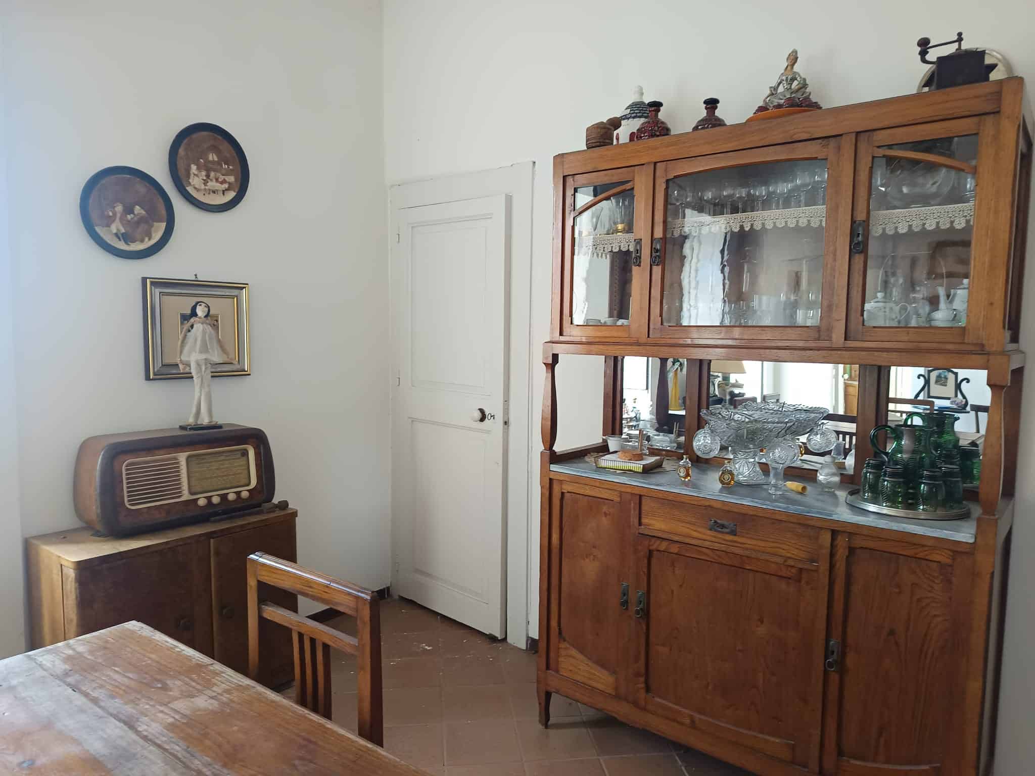 Anticamera con mobile in legno e oggetti decorativi, ambiente classico e accogliente.