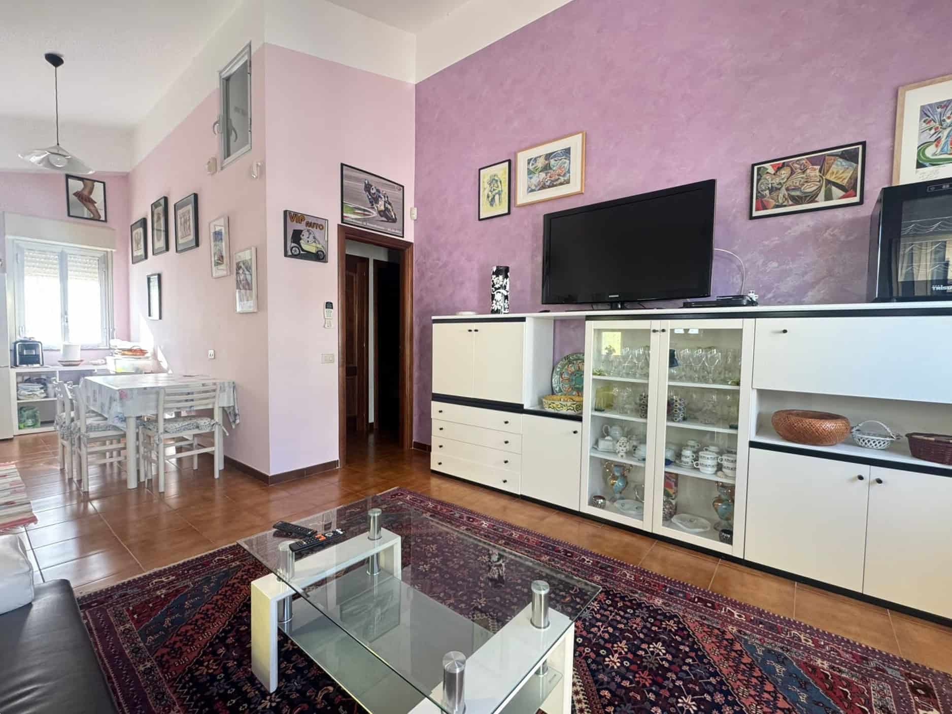 Appartamento moderno con soggiorno elegante, pareti colorate e arredi funzionali, ideale per vivere in comfort e stile. Perfetto per famiglie o coppie che cercano un'abitazione accogliente e ben arred.