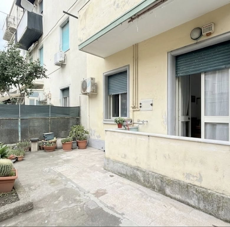 Appartamento con balcone e giardino esterno, zona residenziale tranquilla, con piante e decorazioni, ideale per relax e vita all'aperto.
