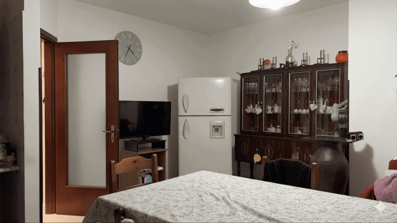 Pannello di cucina con frigorifero, mobile in legno con vetrine e oggetti decorativi, ambiente domestico accogliente e ben arredato.