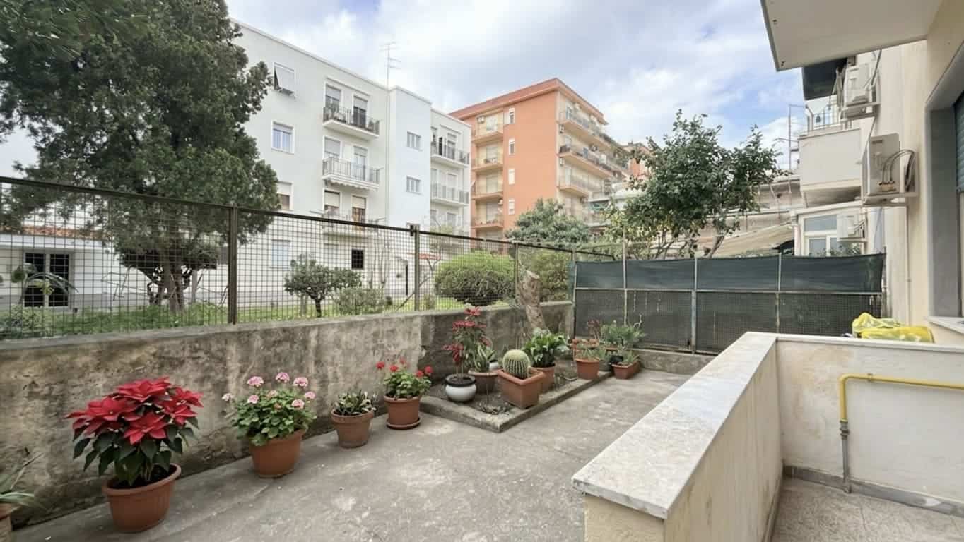 Balcone di un appartamento con piante in vaso e vista su edifici residenziali, ideale per relax e coltivazioni domestiche.