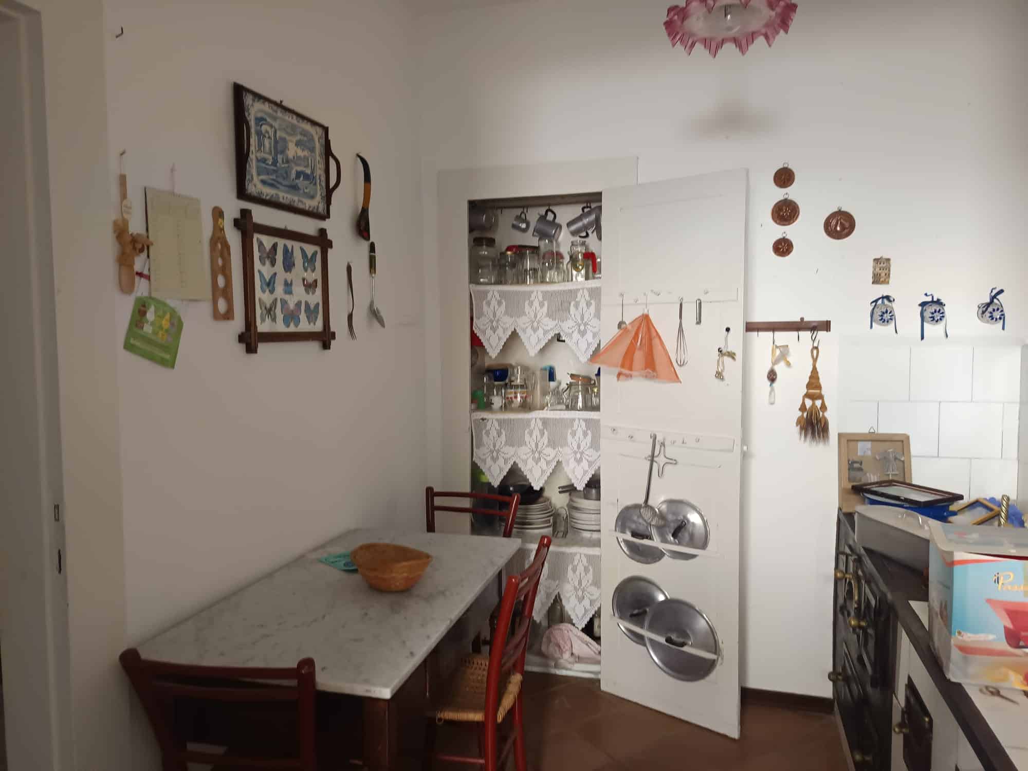 Pannello di cucina con armadietti e utensili, ambiente domestico accogliente e funzionale, ideale per preparare pasti e organizzare la casa. Cucina ben arredata con dettagli decorativi e spazio di lav.