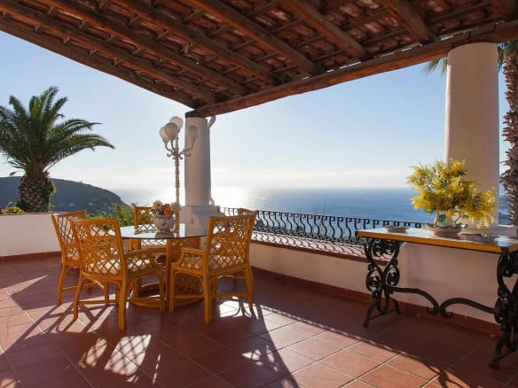 Godimento di una terrazza con vista mare, arredamento elegante e piante tropicali, ideale per relax e cene all'aperto in un ambiente esclusivo e panoramico. Perfetta per case di lusso e proprietà con.