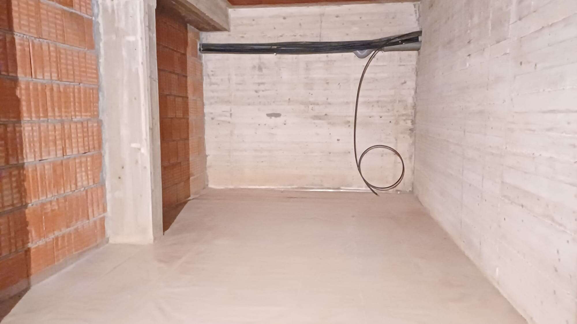 Porte aperte di un appartamento in costruzione con pareti in mattoni e cemento, pronto per lavori di finitura e personalizzazione. Ideale per chi cerca soluzioni immobiliari innovative e personalizzab.