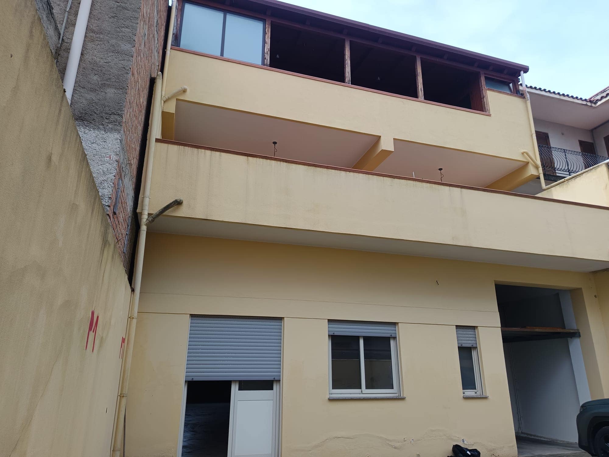 Ampia facciata di edificio residenziale con balcone e grandi finestre, in un contesto urbano, con dettagli architettonici moderni e colori neutri, ideale per chi cerca soluzioni abitative contemporane.