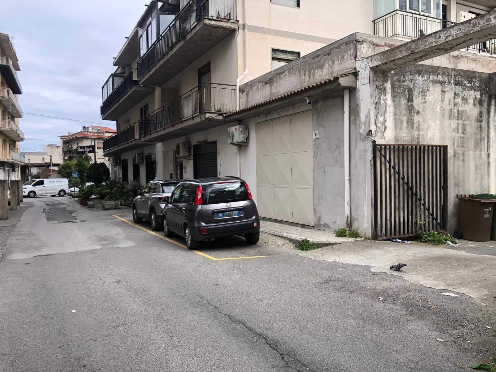 Auto in sosta davanti a un edificio residenziale in un'area urbana, con parcheggi disponibili e strutture moderne, ideale per chi cerca soluzioni di alloggio o investimento immobiliare a NextCasa.