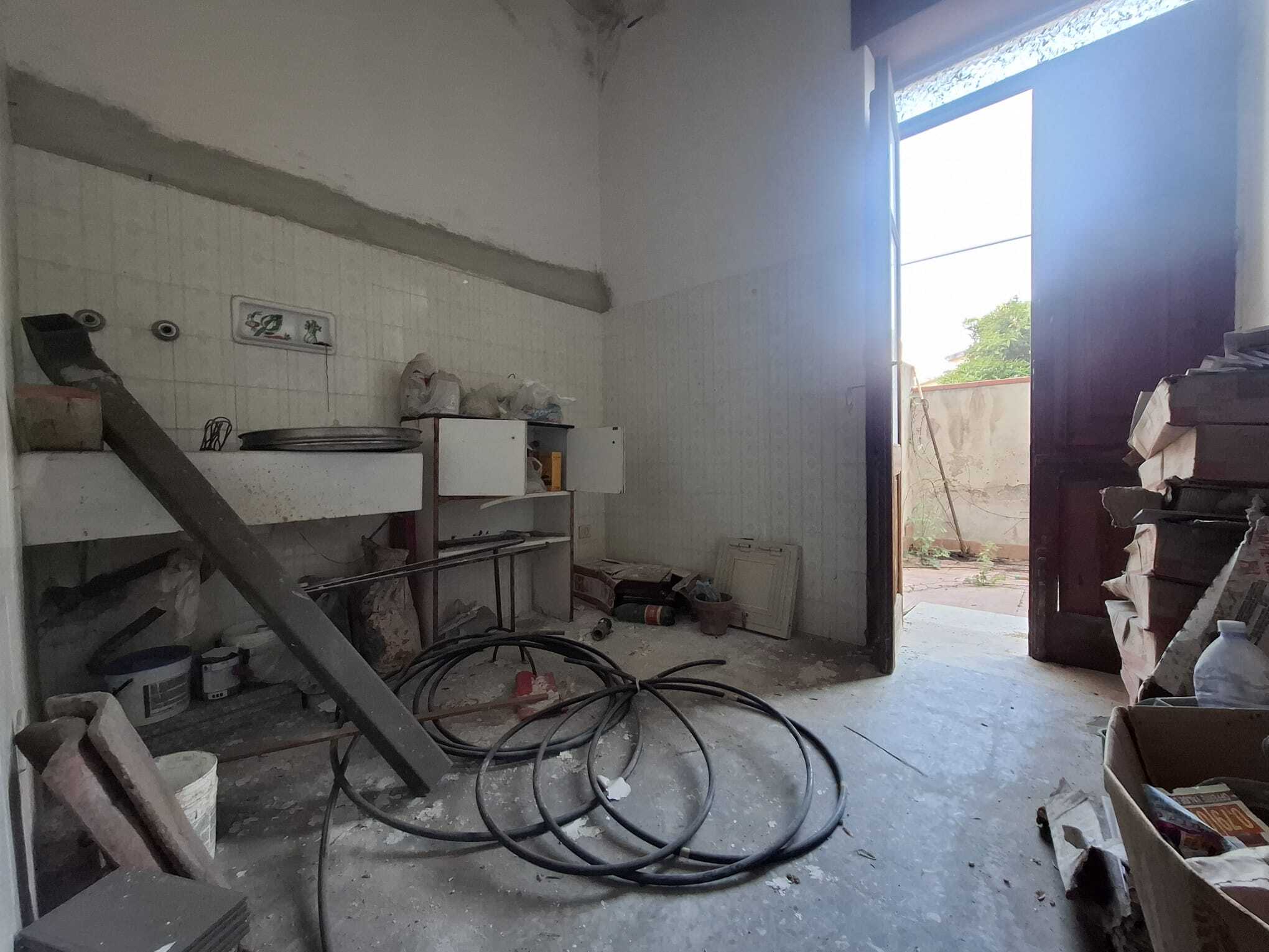 Immagine di un garage in fase di ristrutturazione con attrezzi e materiali da lavoro, pronto per essere rinnovato.