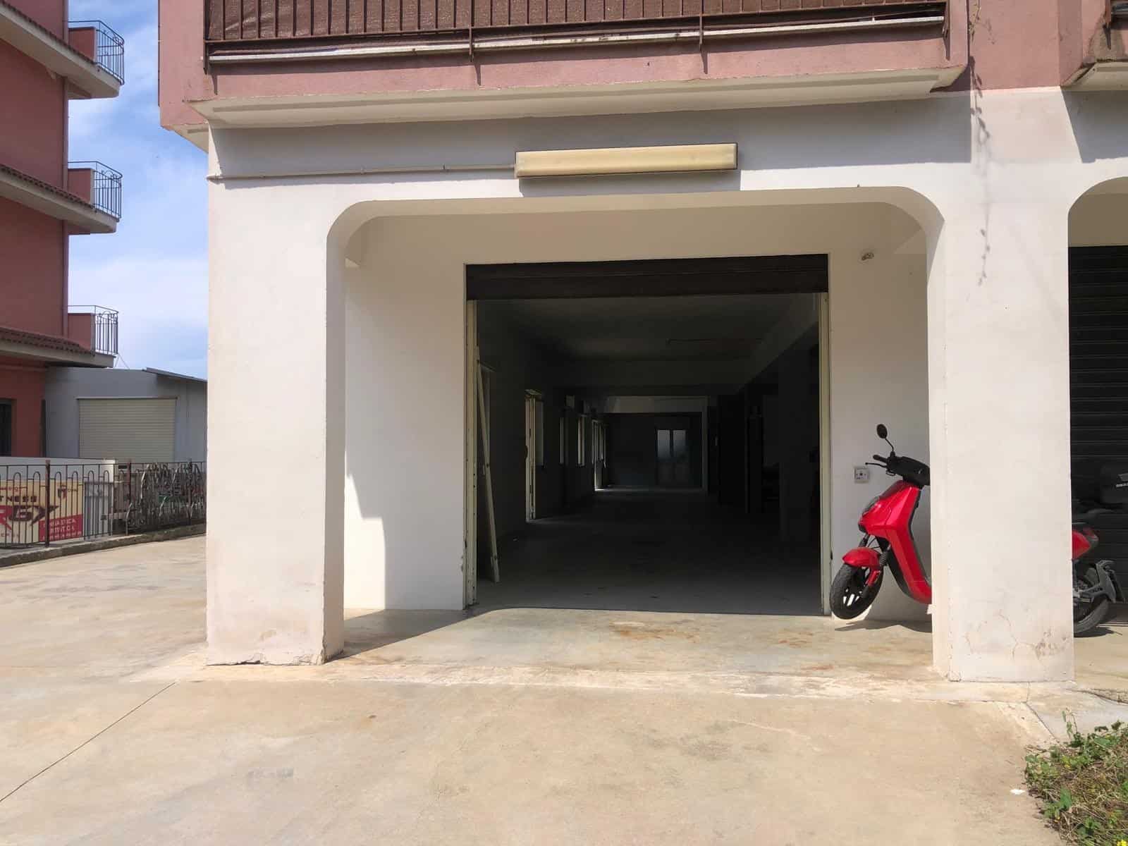 Parcheggio coperto in un edificio residenziale, con scooter rosso parcheggiato all'ingresso, spazio ampio e ben illuminato, ideale per residenti e visitatori, in zona urbana tranquilla e ben servita.