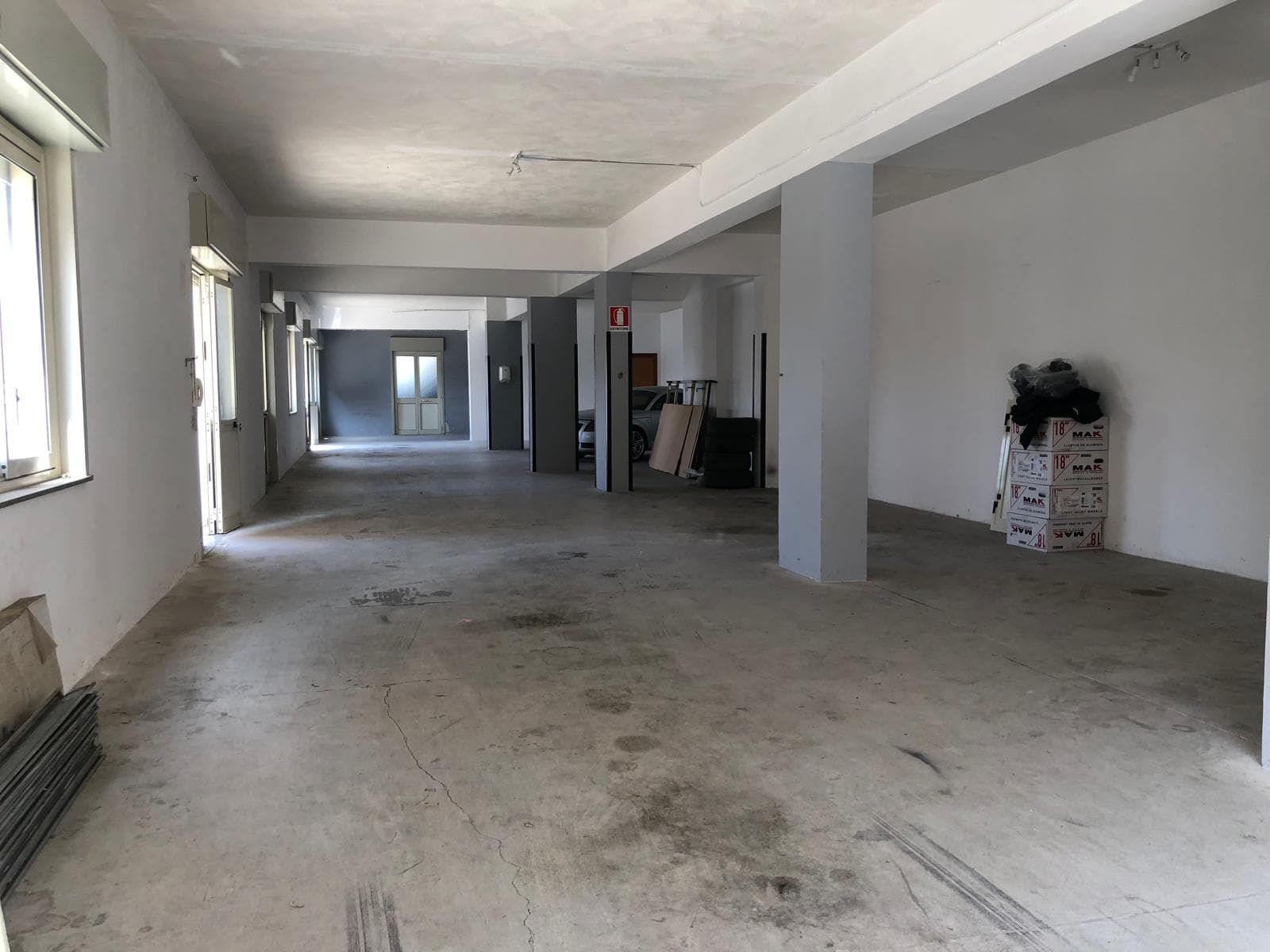 Spazio commerciale vuoto in fase di ristrutturazione, ampio e luminoso, pronto per personalizzazione e allestimento.