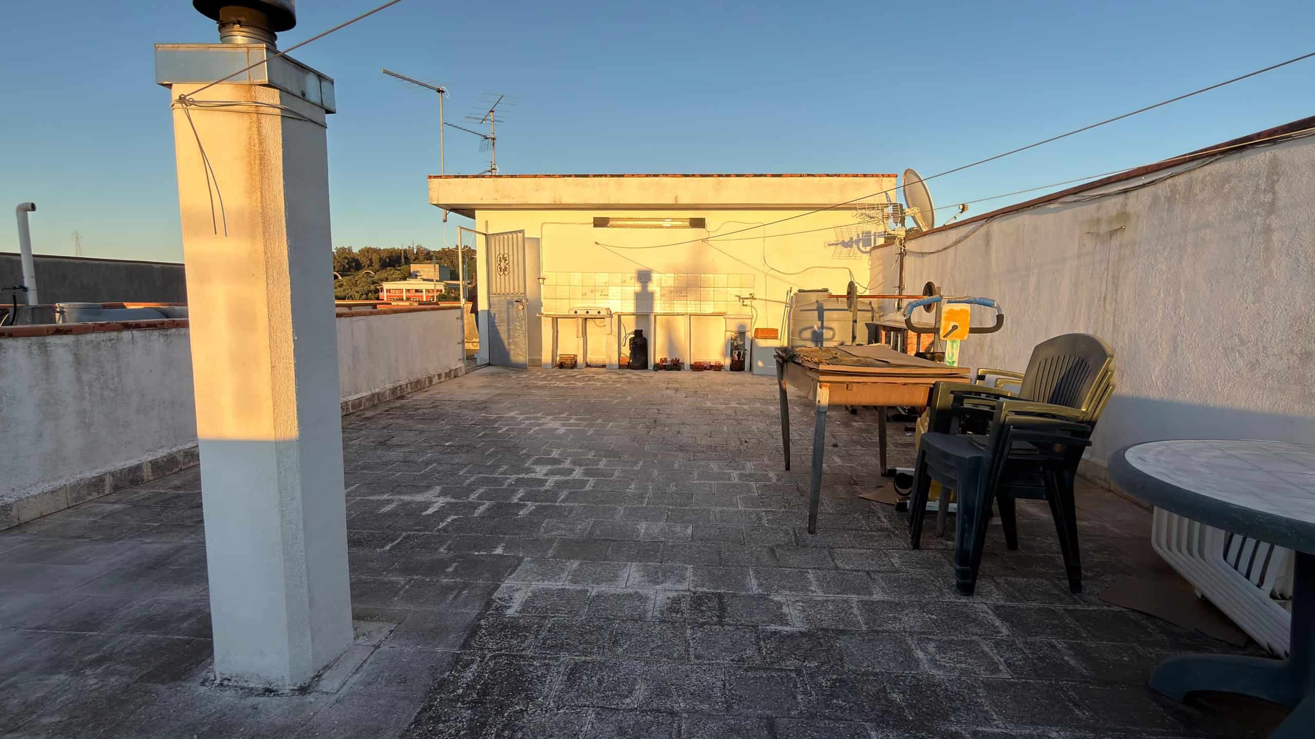 Aggiunta di un'area terrazza con mobili da esterno, sedie e tavoli, vista al tramonto, ideale per relax e socializzazione in un appartamento in vendita o in affitto a NextCasa.