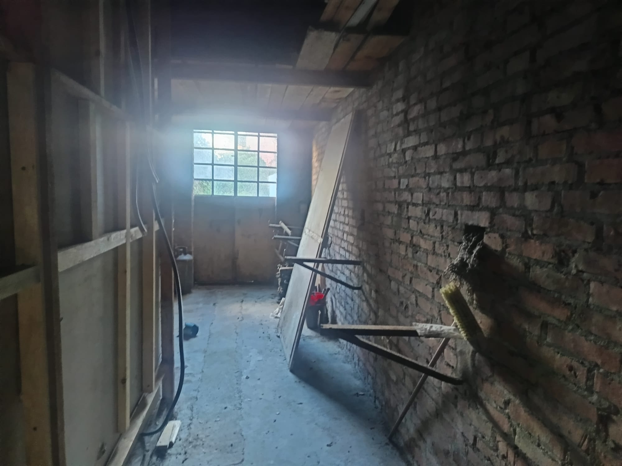 Aggiunta di un'immagine di un ambiente in fase di ristrutturazione o costruzione, con pareti in mattoni e attrezzi da lavoro.