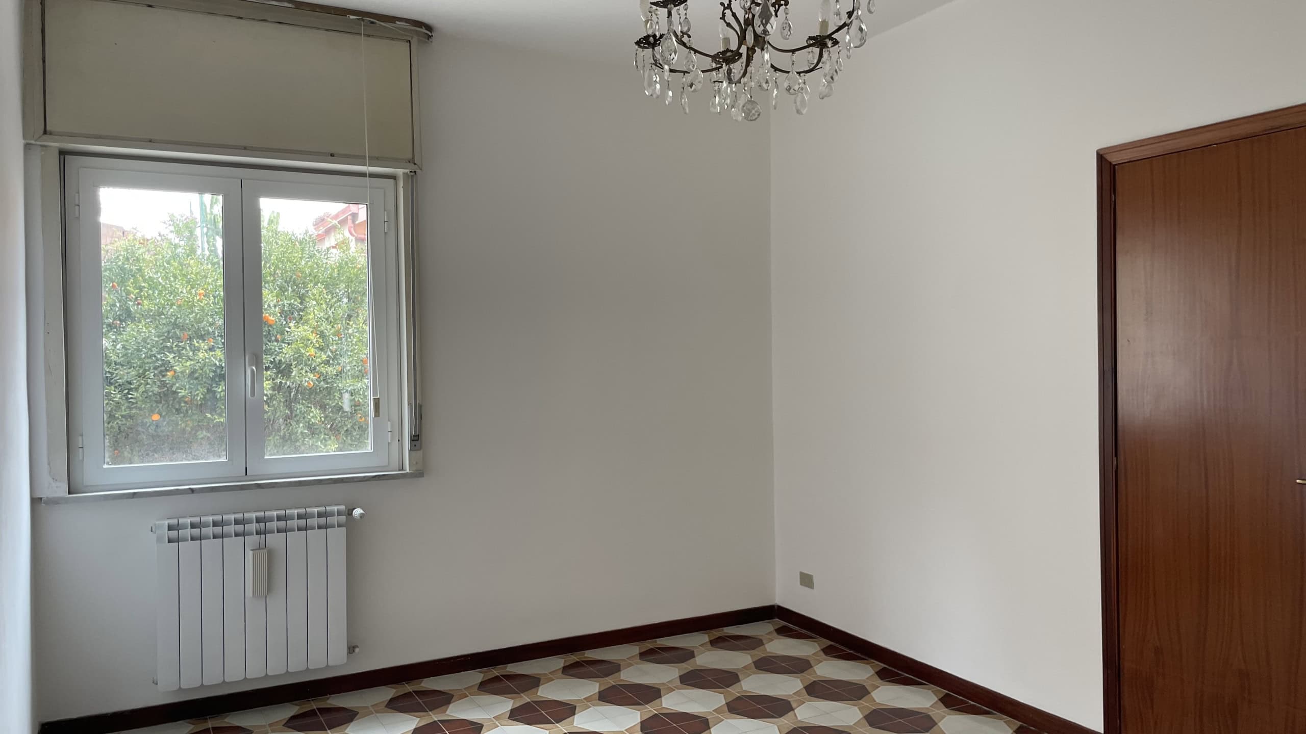 Appartamento vuoto con finestra e riscaldamento, stanza luminosa e spaziosa.