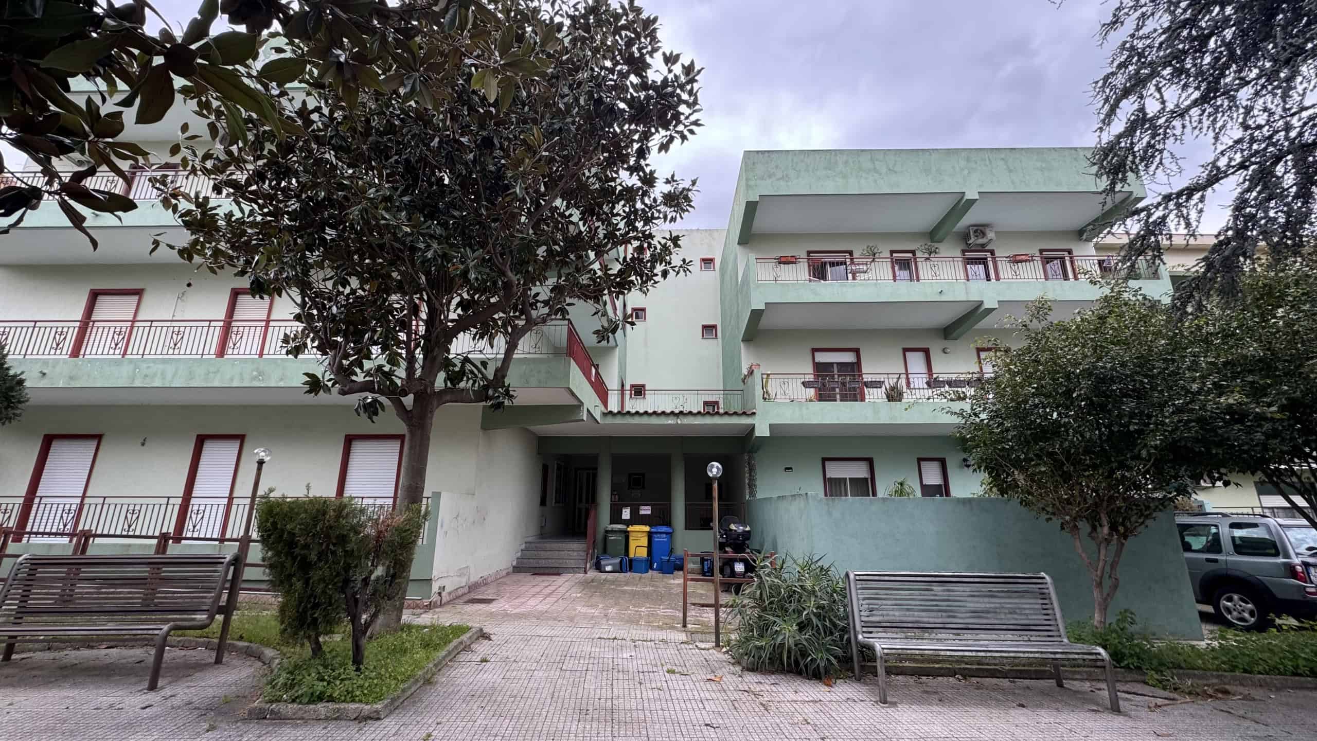 Aggiungi un'immagine di un edificio residenziale moderno con balconi e aree verdi circostanti, ideale per annunci immobiliari e affitti a NextCasa.