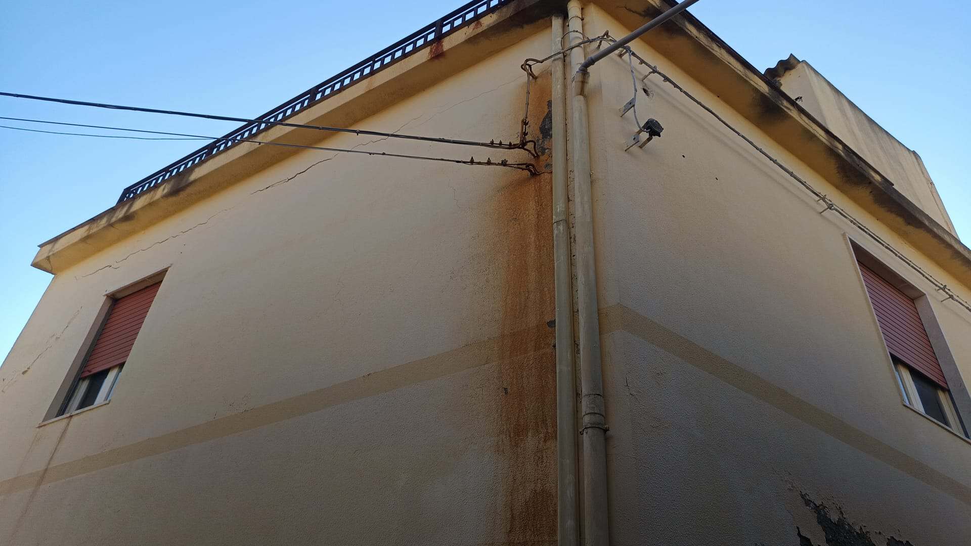 Villa con pareti esterne che mostrano segni di umidità e muffa, evidenziando la necessità di interventi di ristrutturazione e manutenzione.
