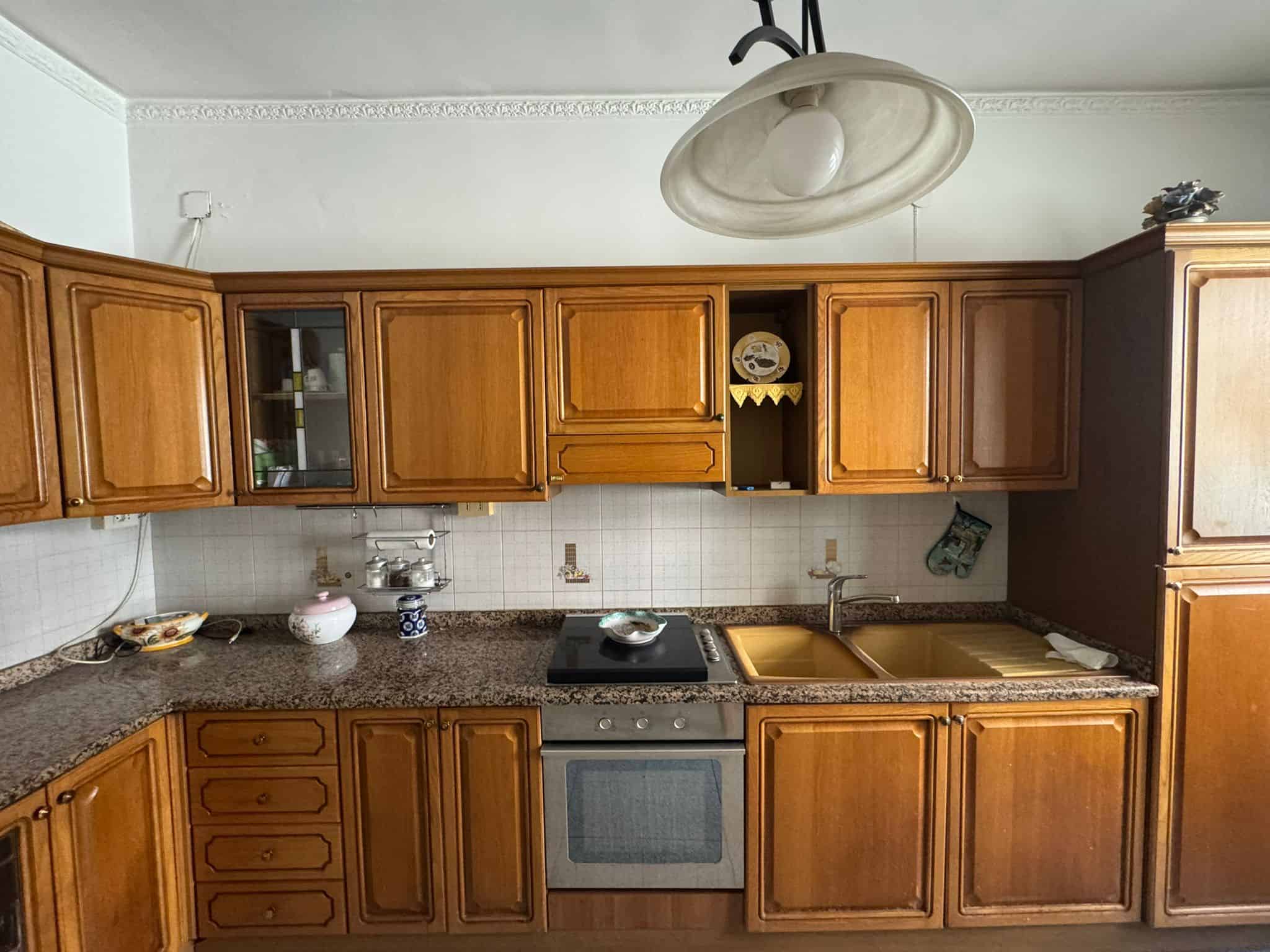 Elegante cucina in stile classico con mobili in legno di alta qualità, piano di lavoro in granito e elettrodomestici moderni, ideale per cucinare e socializzare in casa.