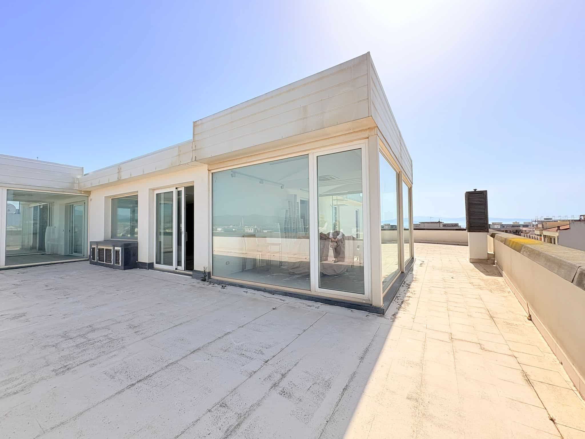 Balcone panoramico con vista sul mare, spazio esterno di un appartamento moderno in centro città, ideale per relax e convivialità, con ampie vetrate e arredi minimalisti.