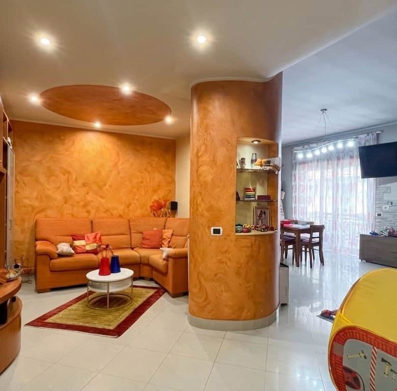 Appartamento moderno con soggiorno accogliente, divano angolare e zona pranzo luminosa, ideale per famiglie e soggiorni confortevoli, con arredi funzionali e decorazioni calde.