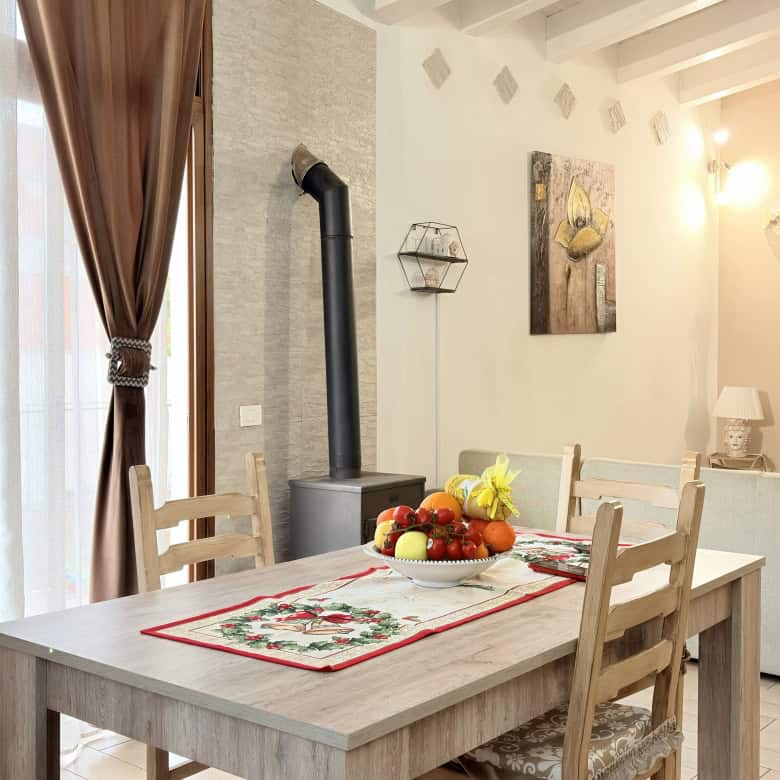 Una sala da pranzo moderna e accogliente con tavolo in legno, sedie abbinate, e decorazioni eleganti, ideale per famiglie e incontri conviviali.