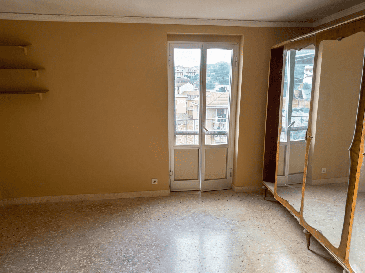 Appartamento luminoso con balcone e vista sulla città, ideale per investimento o residenza, con pavimento in marmo e pareti neutre, pronto per personalizzazione.