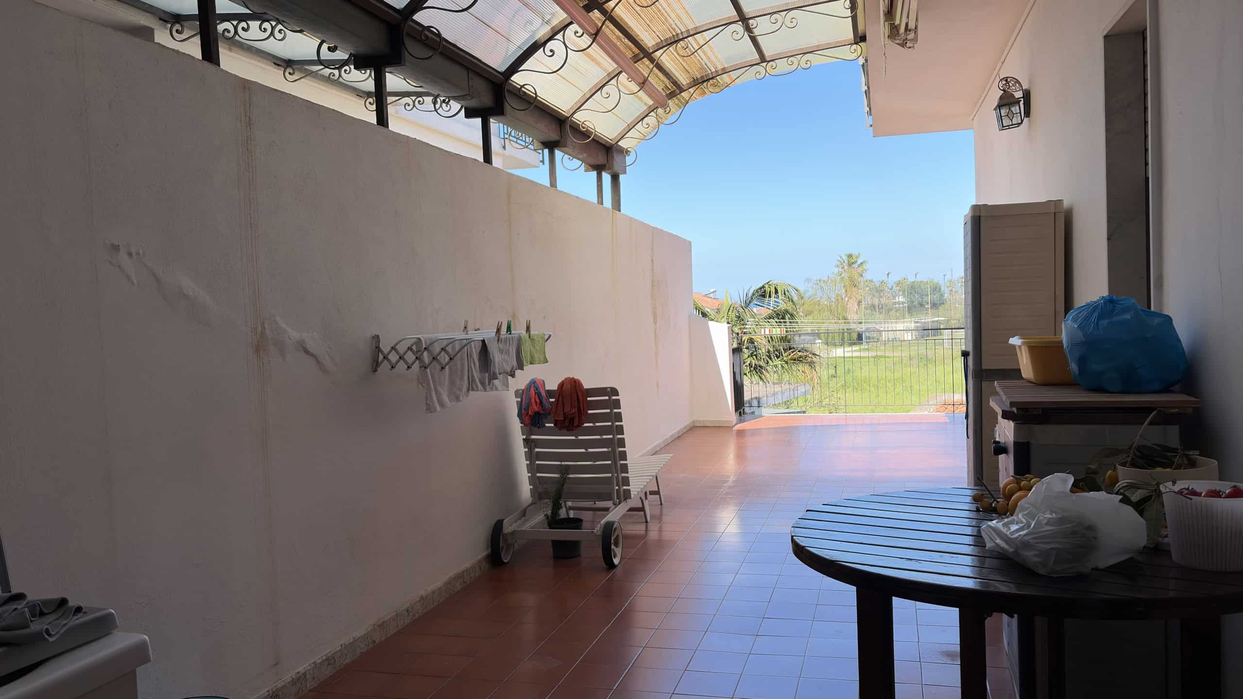 Balcone spazioso con vista panoramica, coperto da tenda parasole, ideale per relax e momenti all'aperto, con arredi pratici e spazio per attività all'aperto.