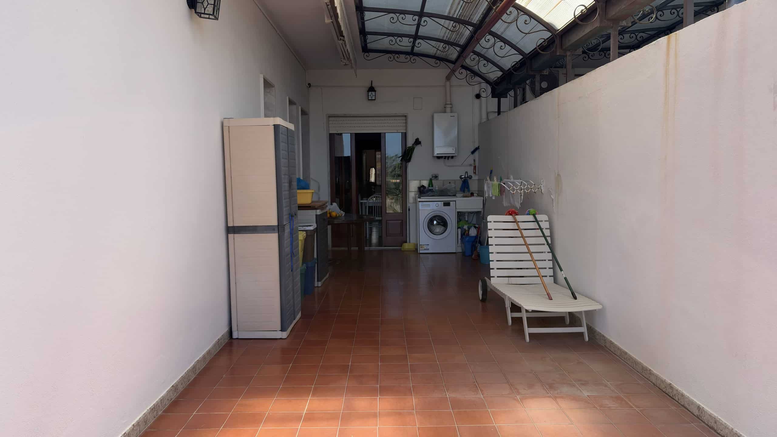 Balcone con arredi esterni, panchina e lavatrice, spazio abitativo luminoso e funzionale, ideale per relax e praticità in appartamento a NextCasa.