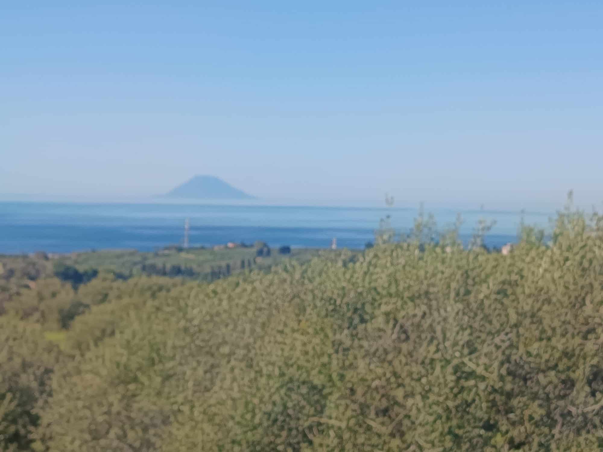 Vista panoramica mare e isola dal giardino di una casa in vendita a NextCasa, con ampio spazio verde e paesaggio marino.