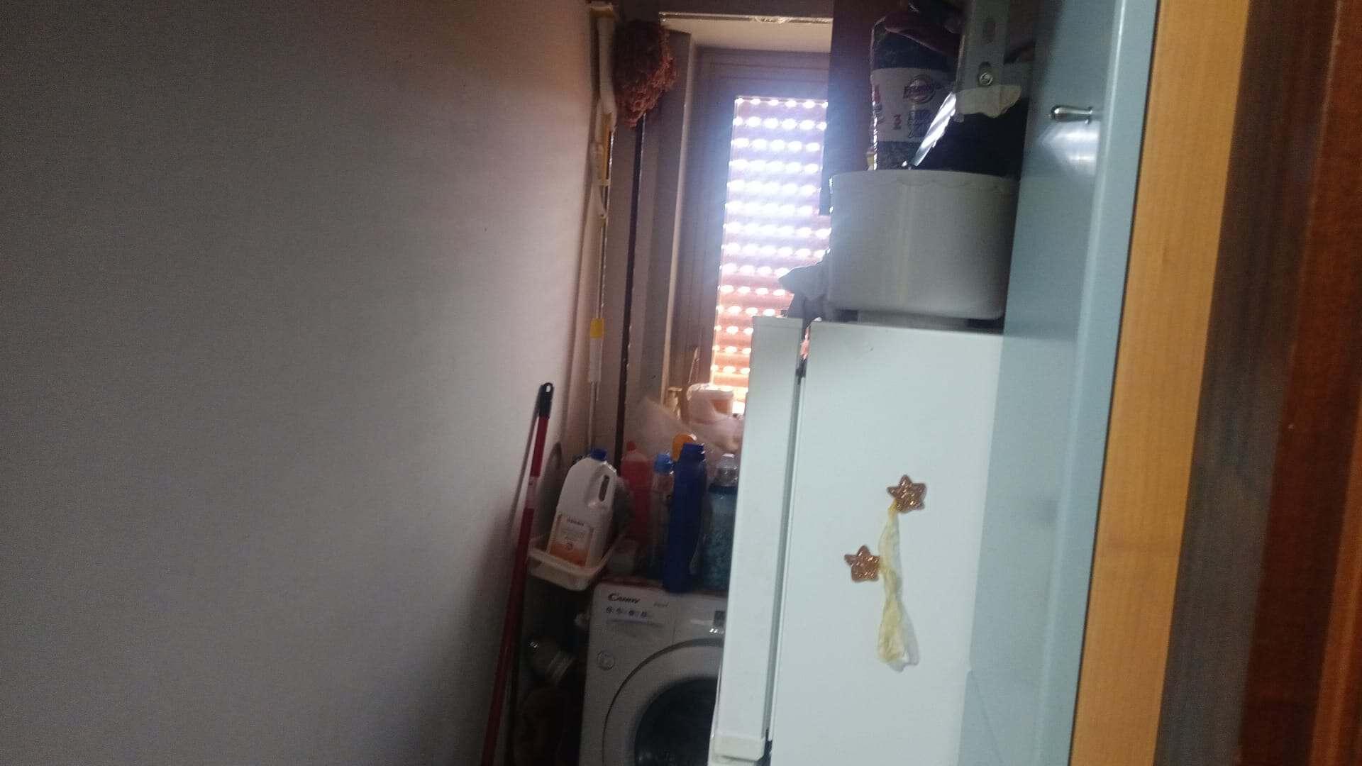 Spazio lavanderia compatto con lavatrice, armadi e ripiani per organizzare vestiti e detersivi in modo efficiente. Ambiente funzionale e ben organizzato, ideale per ottimizzare gli spazi in casa.