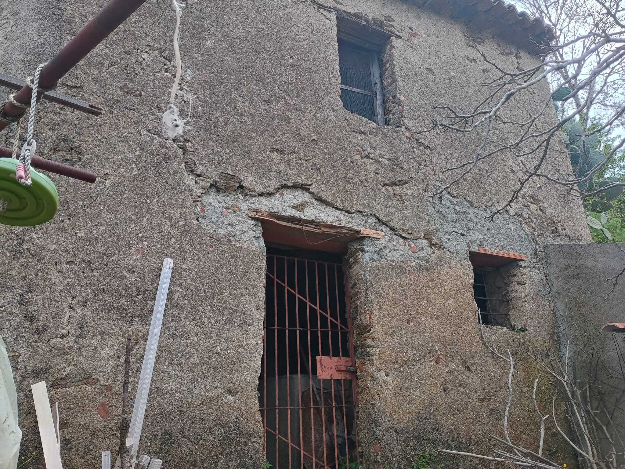 Porte in ferro battuto e pareti in pietra di un edificio storico in stile rustico.
