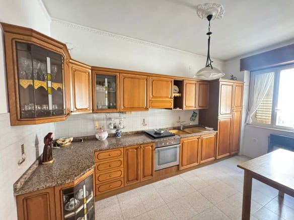 Armadio e cucina in legno con elettrodomestici integrati in cucina abitabile luminosa e spaziosa.
