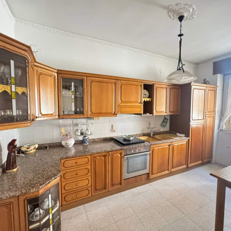 Armadio e cucina in legno con elettrodomestici integrati in cucina abitabile luminosa e spaziosa.