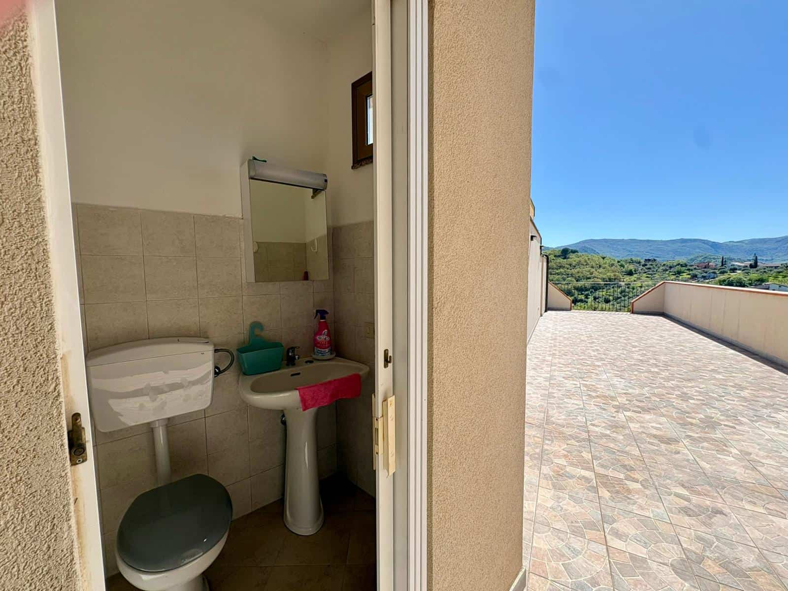 Lavabo e servizi igienici in un appartamento con vista panoramica sulle colline toscane. Spazio compatto e funzionale, ideale per soggiorni confortevoli e rilassanti in natura.